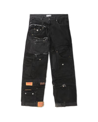 A pair of heavily patched black denim cargo pants with multiple utility pockets, frayed details, and orange brand patches, shown flat against a white background.